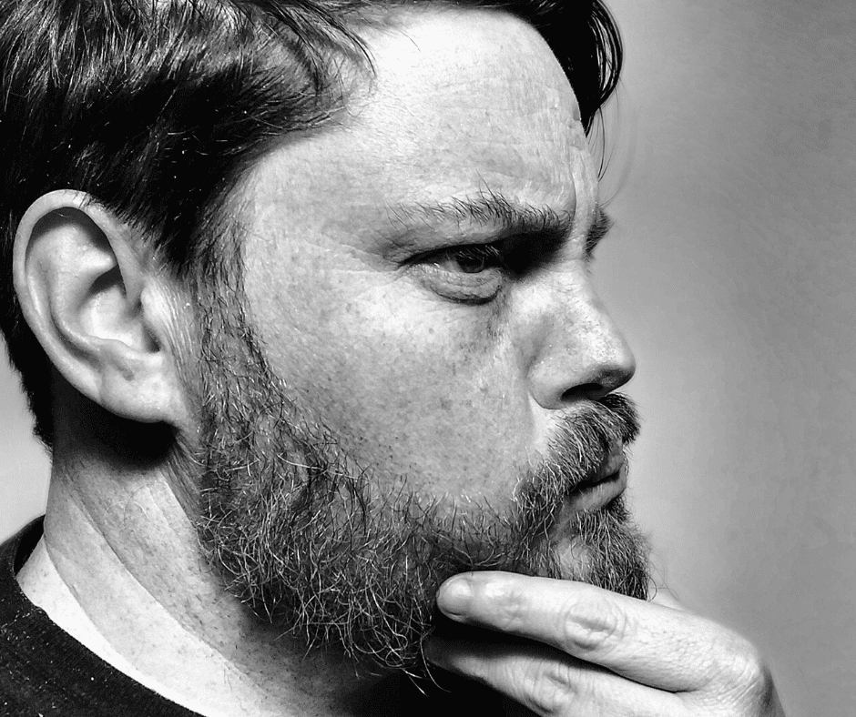 Tim Nash frowning and stroking his beard